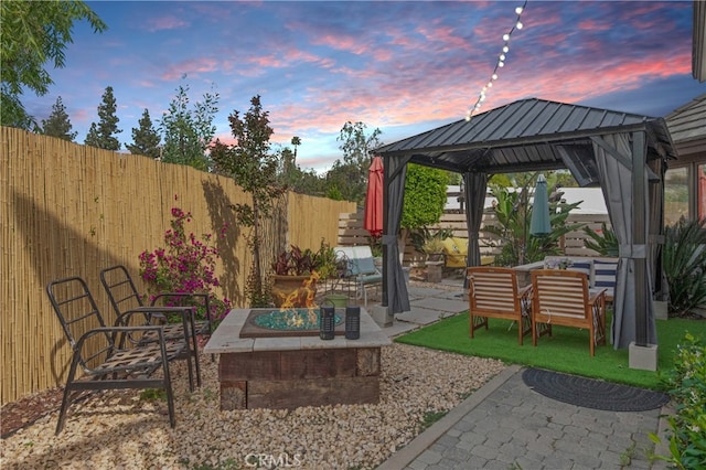6978 Withers Rd, Riverside, CA 92506 - patio terrace at dusk featuring a fire pit, a gazebo, a patio area, and a fenced backyard
