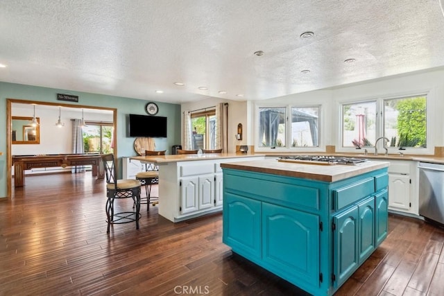 6978 Withers Rd, Riverside, CA 92506 - kitchen with wood counters, appliances with stainless steel finishes, a textured ceiling, white cabinets, and a kitchen island