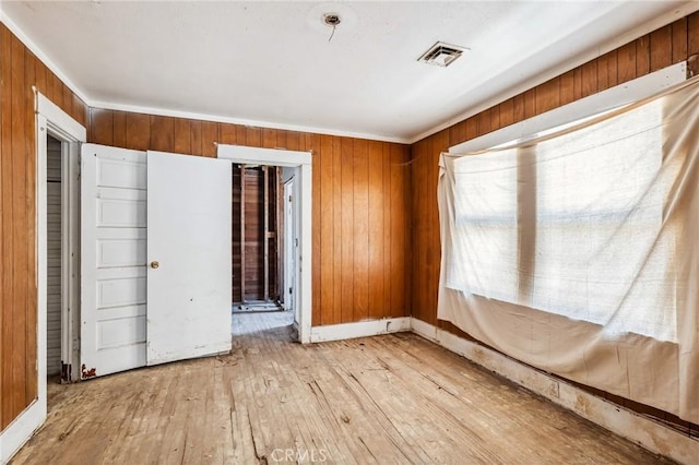 518 A St, Needles, CA 92363 - unfurnished bedroom with light wood finished floors, wooden walls, and baseboards