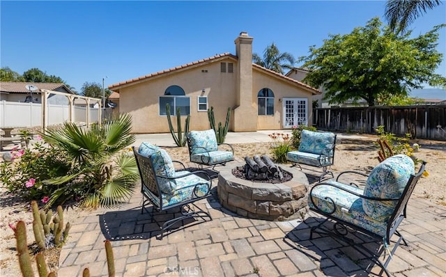 2069 W Fairview Dr, Rialto, CA 92377 - fenced backyard with an outdoor fire pit, a patio, and french doors
