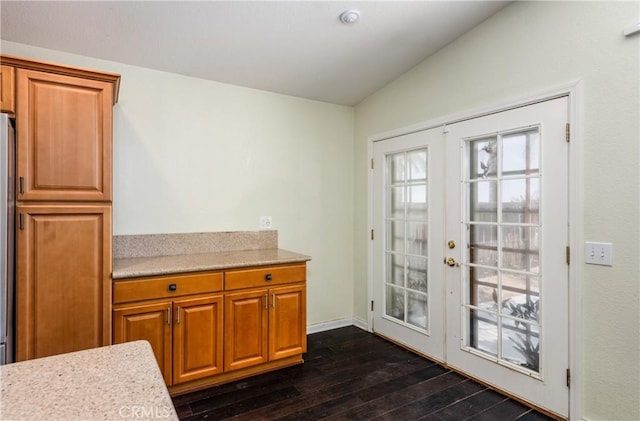 2069 W Fairview Dr, Rialto, CA 92377 - kitchen with french doors, dark wood-type flooring, light countertops, vaulted ceiling, and brown cabinets