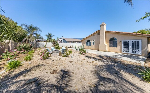 2069 W Fairview Dr, Rialto, CA 92377 - rear view of property with french doors, stucco siding, a patio, and a chimney