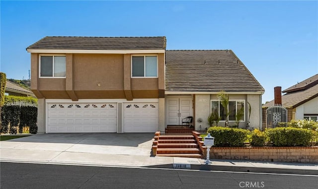 11818 Pocasset Dr, Whittier, CA 90601 - view of front of house featuring an attached garage, stucco siding, driveway, and a tile roof