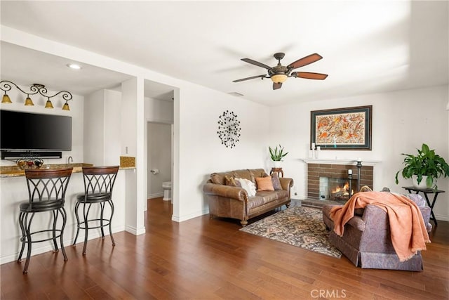 11818 Pocasset Dr, Whittier, CA 90601 - living area with wood finished floors, a ceiling fan, a brick fireplace, and recessed lighting