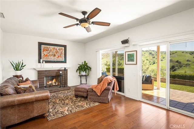 11818 Pocasset Dr, Whittier, CA 90601 - living area with wood finished floors, a brick fireplace, and a ceiling fan