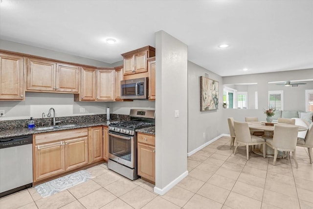 970 Carlsbad St, San Diego, CA 92114 - kitchen with stainless steel appliances, a sink, dark stone countertops, light tile patterned floors, and recessed lighting