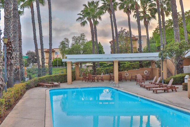 5787 Barbary Pl, Bonsall, CA 92003 - pool at dusk featuring a community pool and a patio area