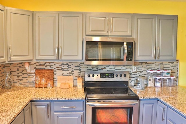 5787 Barbary Pl, Bonsall, CA 92003 - kitchen featuring appliances with stainless steel finishes, gray cabinetry, decorative backsplash, and light stone countertops