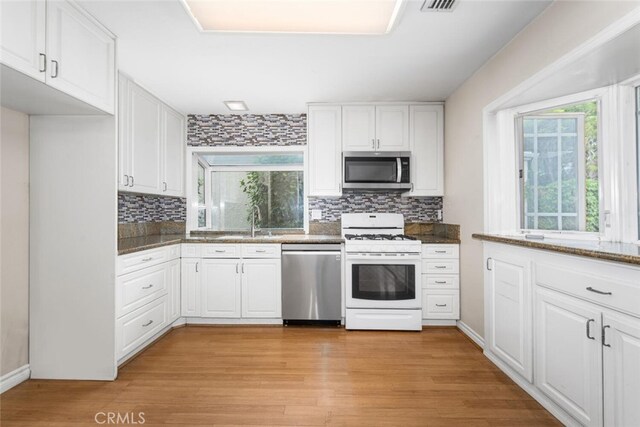 3 Rock Spgs, Irvine, CA 92604 - kitchen featuring stainless steel appliances, backsplash, white cabinetry, and light wood-style flooring