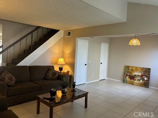 61765 Arroyo Rd Unit 5, Palm Springs, CA 92264 - tiled living area with a textured ceiling and stairway