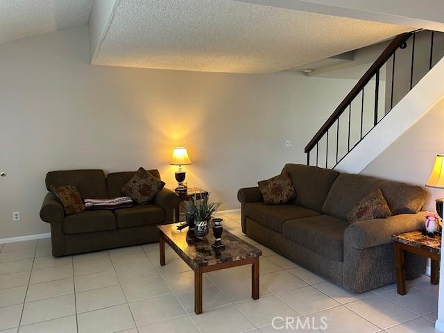 61765 Arroyo Rd Unit 5, Palm Springs, CA 92264 - living area featuring a textured ceiling, stairway, and light tile patterned floors