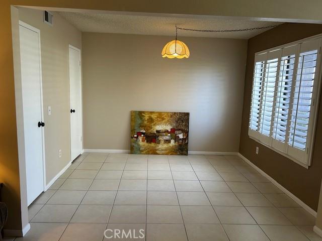 61765 Arroyo Rd Unit 5, Palm Springs, CA 92264 - unfurnished dining area with light tile patterned floors and a textured ceiling