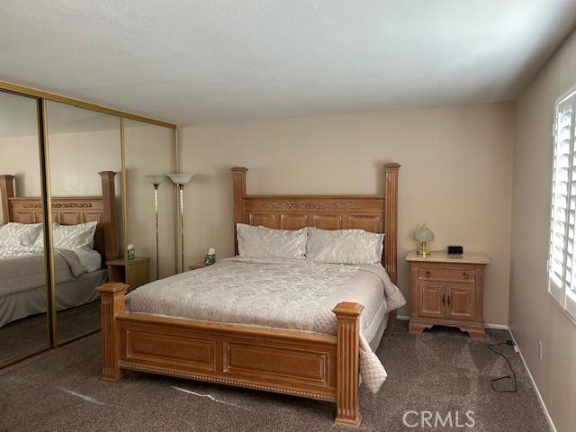 61765 Arroyo Rd Unit 5, Palm Springs, CA 92264 - bedroom featuring dark colored carpet, multiple windows, and a closet
