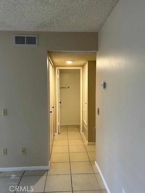 61765 Arroyo Rd Unit 5, Palm Springs, CA 92264 - corridor featuring light tile patterned flooring and a textured ceiling