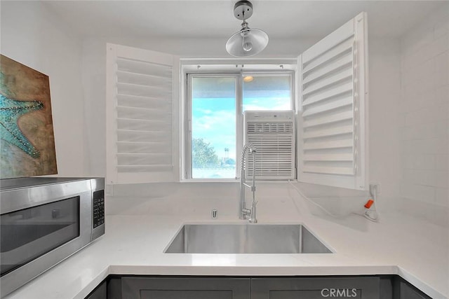810 Edgewood St Unit 302, Inglewood, CA 90302 - kitchen featuring stainless steel microwave, a sink, gray cabinets, light countertops, and hanging light fixtures
