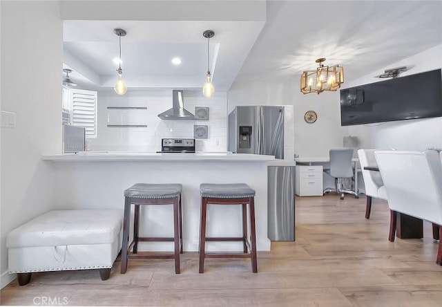810 Edgewood St Unit 302, Inglewood, CA 90302 - kitchen featuring stainless steel refrigerator with ice dispenser, wall chimney range hood, a breakfast bar area, tasteful backsplash, and refrigerator