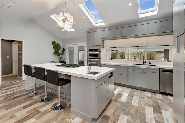 2815 E Coolidge Ave, Orange, CA 92867 - kitchen with a sink, gray cabinets, a skylight, modern cabinets, and lofted ceiling