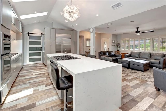 2815 E Coolidge Ave, Orange, CA 92867 - kitchen featuring stainless steel appliances, modern cabinets, light countertops, a kitchen island, and vaulted ceiling