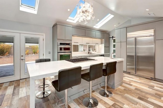 2815 E Coolidge Ave, Orange, CA 92867 - kitchen with stainless steel appliances, a skylight, lofted ceiling, light countertops, and gray cabinets