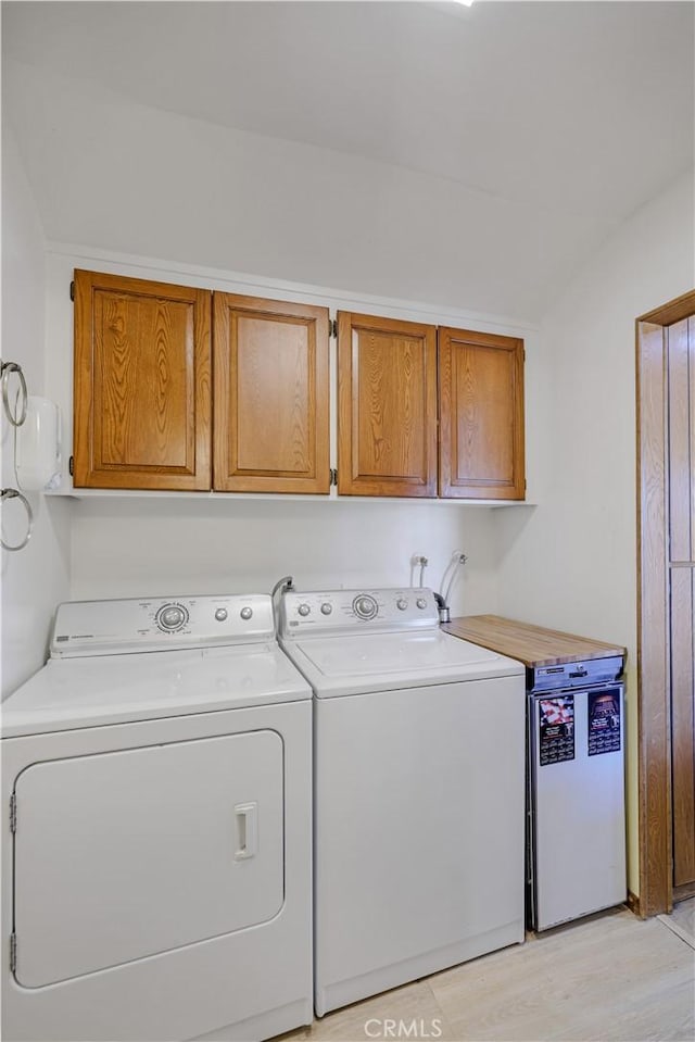 14242 Clarissa Ln, North Tustin, CA 92705 - washroom featuring cabinet space, washing machine and clothes dryer, and light wood-style flooring