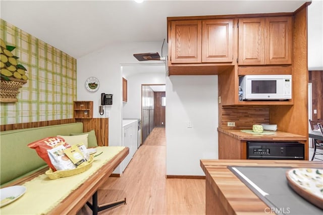 14242 Clarissa Ln, North Tustin, CA 92705 - kitchen with white microwave, lofted ceiling, light wood-type flooring, wallpapered walls, and brown cabinetry