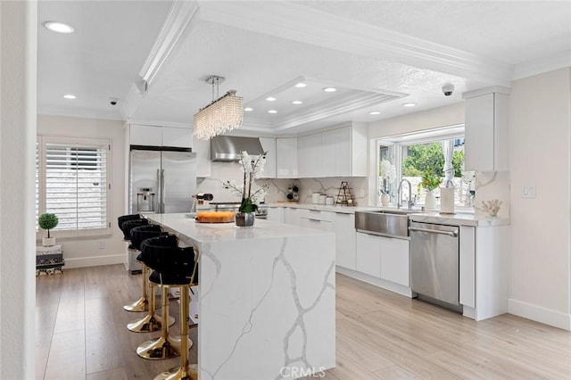 2160 S Hammatt, Anaheim, CA 92802 - kitchen with appliances with stainless steel finishes, crown molding, wall chimney range hood, a sink, and white cabinetry
