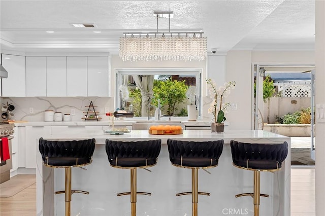 2160 S Hammatt, Anaheim, CA 92802 - kitchen featuring modern cabinets, white cabinetry, plenty of natural light, a kitchen breakfast bar, and a textured ceiling