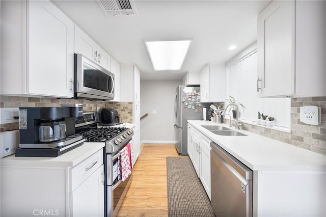 22123 Figueroa St Unit 144, Carson, CA 90745 - kitchen with appliances with stainless steel finishes, a sink, decorative backsplash, light countertops, and white cabinets