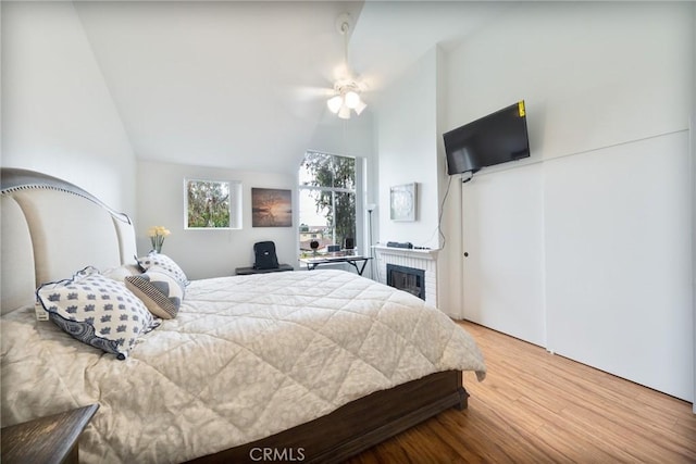 22123 Figueroa St Unit 144, Carson, CA 90745 - bedroom featuring wood finished floors, vaulted ceiling, a fireplace, and a ceiling fan