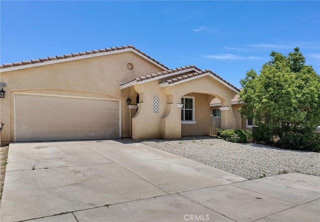 1760 Terrace Ave, Colton, CA 92324 - mediterranean / spanish home featuring stucco siding, a garage, concrete driveway, and a tile roof