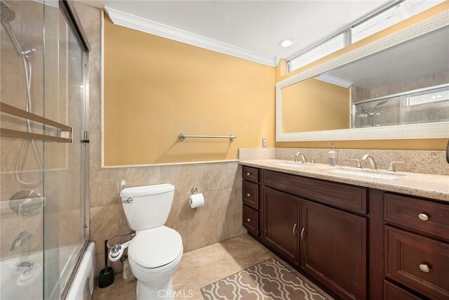 4541 Amberwood Ave, La Palma, CA 90623 - full bathroom featuring tile walls, double vanity, crown molding, shower / bath combination with glass door, and toilet