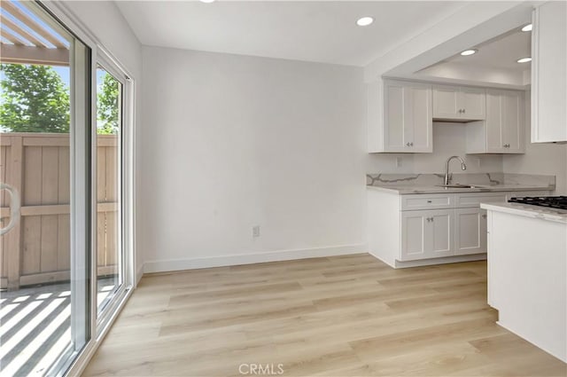 31278 Calle San Juan Unit 12F, San Juan Capistrano, CA 92675 - kitchen with a sink, white cabinetry, recessed lighting, light wood-style floors, and baseboards