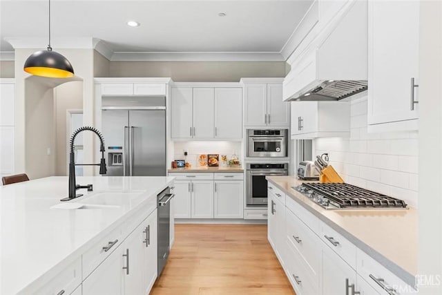 12312 Ashlyn Dr, Bakersfield, CA 93311 - kitchen with appliances with stainless steel finishes, crown molding, a sink, decorative light fixtures, and light countertops
