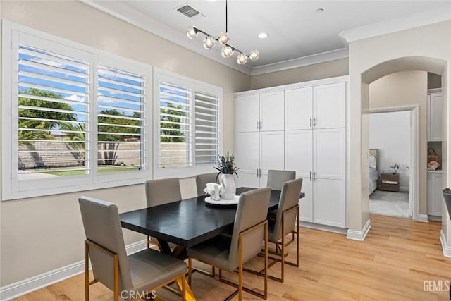 12312 Ashlyn Dr, Bakersfield, CA 93311 - dining space featuring arched walkways, light wood-style floors, crown molding, and baseboards