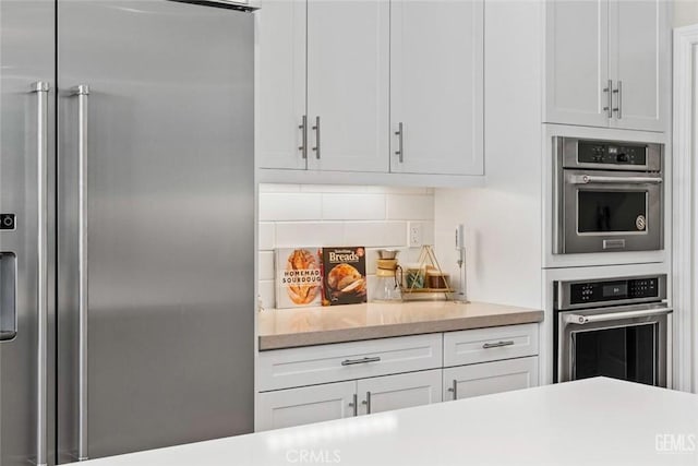 12312 Ashlyn Dr, Bakersfield, CA 93311 - kitchen with stainless steel appliances, white cabinets, light countertops, and tasteful backsplash