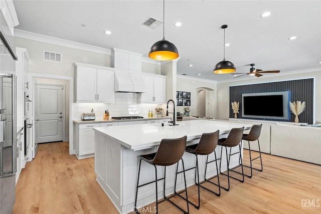 12312 Ashlyn Dr, Bakersfield, CA 93311 - kitchen with crown molding, open floor plan, a ceiling fan, white cabinets, and arched walkways