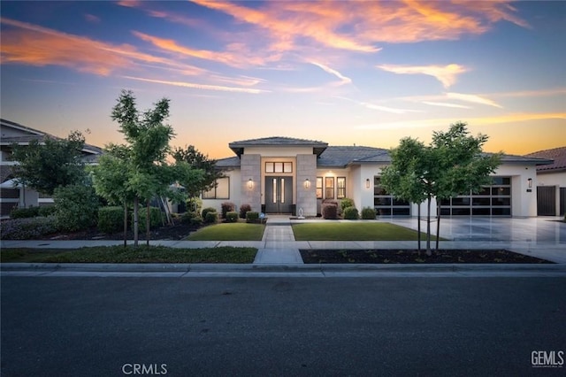 12312 Ashlyn Dr, Bakersfield, CA 93311 - view of front of house featuring a garage, concrete driveway, french doors, stone siding, and stucco siding