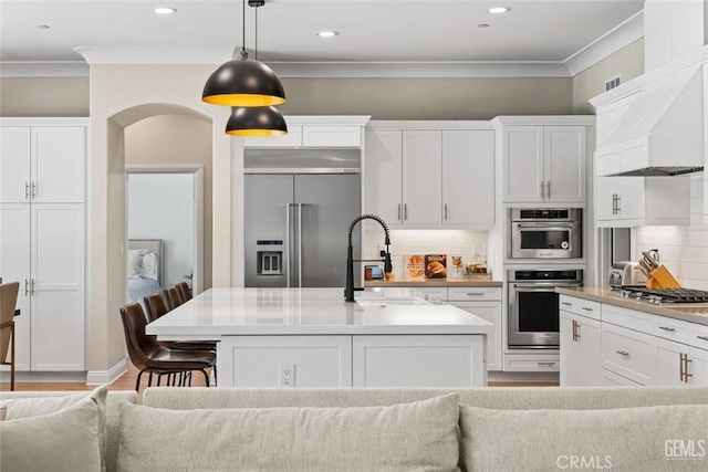 12312 Ashlyn Dr, Bakersfield, CA 93311 - kitchen featuring stainless steel appliances, a sink, ornamental molding, white cabinetry, and decorative light fixtures