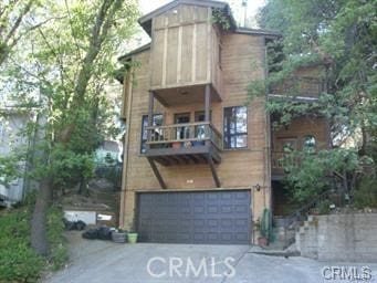 625 Arth Dr, Crestline, CA 92325 - back of property featuring asphalt driveway, an attached garage, and a balcony