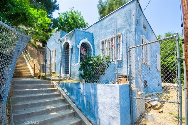 2602 Onyx Dr, Los Angeles, CA 90032 - view of front facade featuring stairway, stucco siding, and a gate