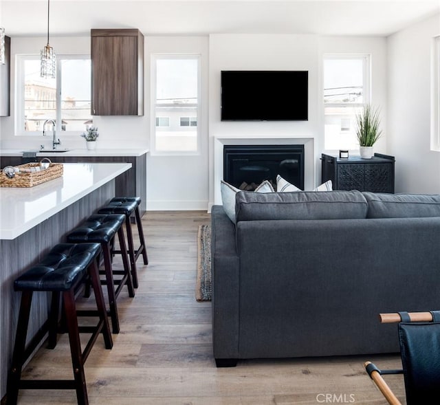 312 35th St, Newport Beach, CA 92663 - living area with light wood finished floors, plenty of natural light, a glass covered fireplace, and baseboards