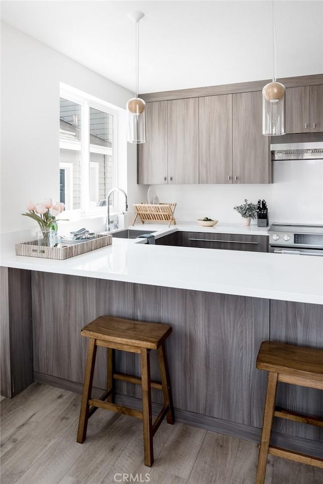 312 35th St, Newport Beach, CA 92663 - kitchen featuring a sink, a breakfast bar, range hood, and light wood finished floors