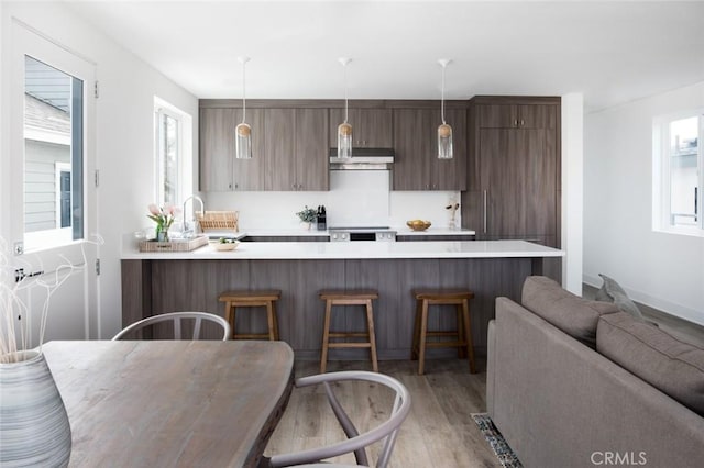 312 35th St, Newport Beach, CA 92663 - kitchen with a peninsula, a kitchen breakfast bar, light countertops, light wood finished floors, and plenty of natural light