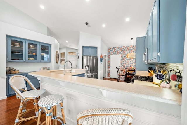 3374 Avocado Vista Ln, Fallbrook, CA 92028 - kitchen featuring appliances with stainless steel finishes, blue cabinets, a peninsula, a kitchen bar, and vaulted ceiling