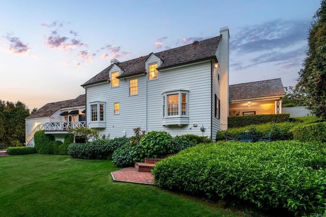 7716 Lookout Dr, La Jolla, CA 92037 - property exterior at dusk featuring a yard, a chimney, and a high end roof