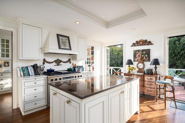 7716 Lookout Dr, La Jolla, CA 92037 - kitchen with stainless steel gas stove, custom range hood, dark wood-type flooring, white cabinets, and recessed lighting