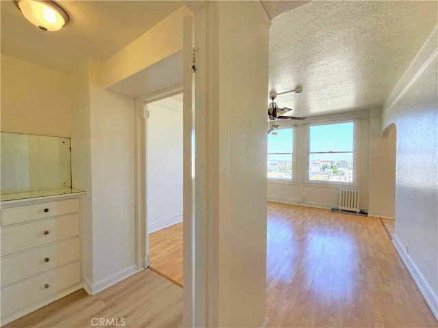 455 E Ocean Blvd Unit 715, Long Beach, CA 90802 - hallway with radiator heating unit, arched walkways, wood finished floors, and a textured ceiling