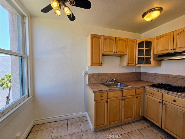 455 E Ocean Blvd Unit 715, Long Beach, CA 90802 - kitchen featuring under cabinet range hood, tile countertops, glass insert cabinets, ceiling fan, and light tile patterned floors
