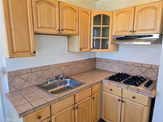 455 E Ocean Blvd Unit 715, Long Beach, CA 90802 - kitchen featuring under cabinet range hood, gas stovetop, tile counters, a sink, and backsplash