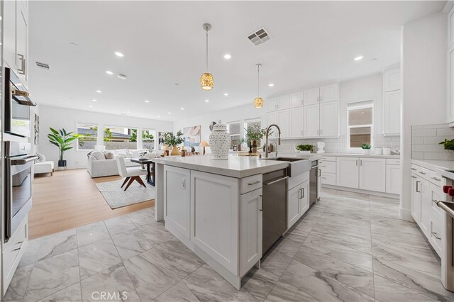 72 Crater, Irvine, CA 92618 - kitchen featuring stainless steel dishwasher, light marble finish floors, a sink, recessed lighting, and decorative backsplash